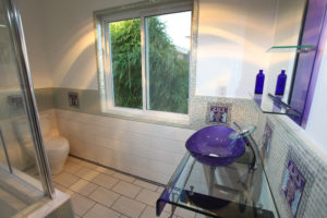 Glass and tile bathroom with custom deco tile