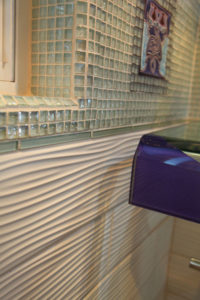 Glass and tile bathroom with custom deco tile